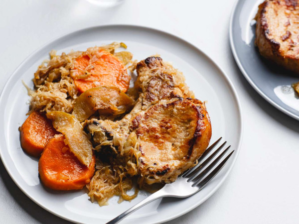 Pork Chops Accompanied by Apples, Sweet Potatoes, and Sauerkraut