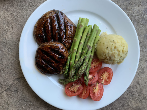 Smoky Grilled Portobello Mushrooms Accompanied by Mashed Cannellini Beans and Harissa